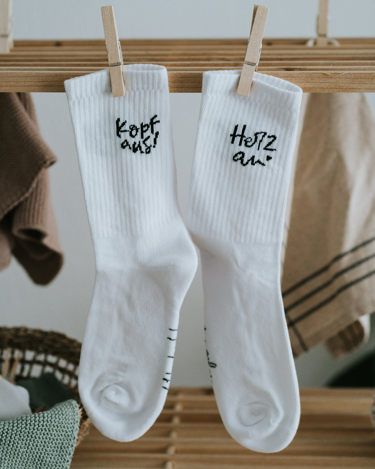 Socken mit Spruch „Kopf aus!“ und „Herz an.“ an der Wäscheleine.