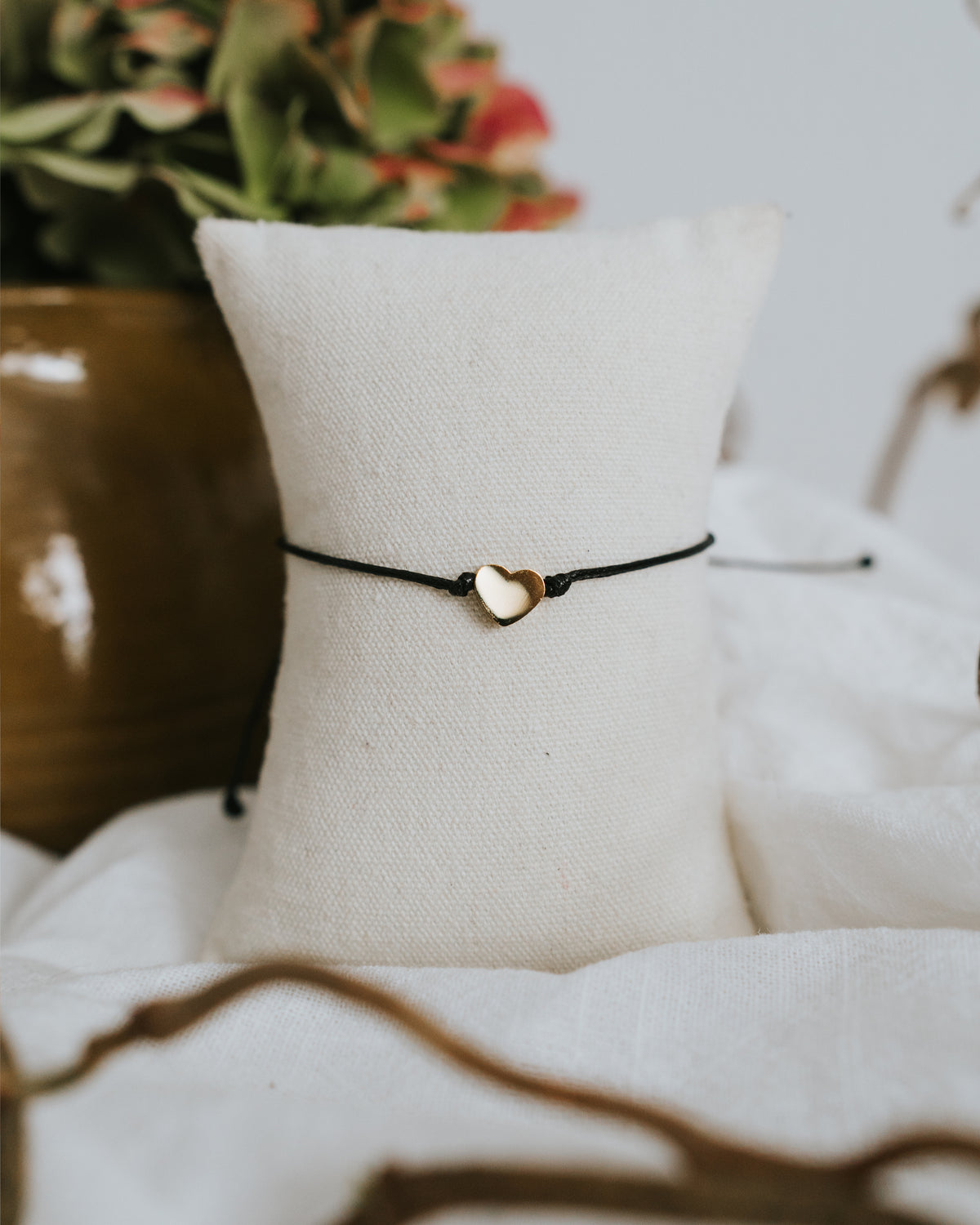Baumwoll-Armband mit goldenem Herz am Schmuckständer.