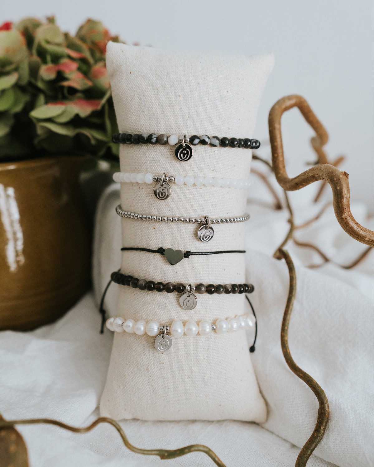 Mehrere Armbänder am Schmuckständer, Edelstahl in Silber vorn.