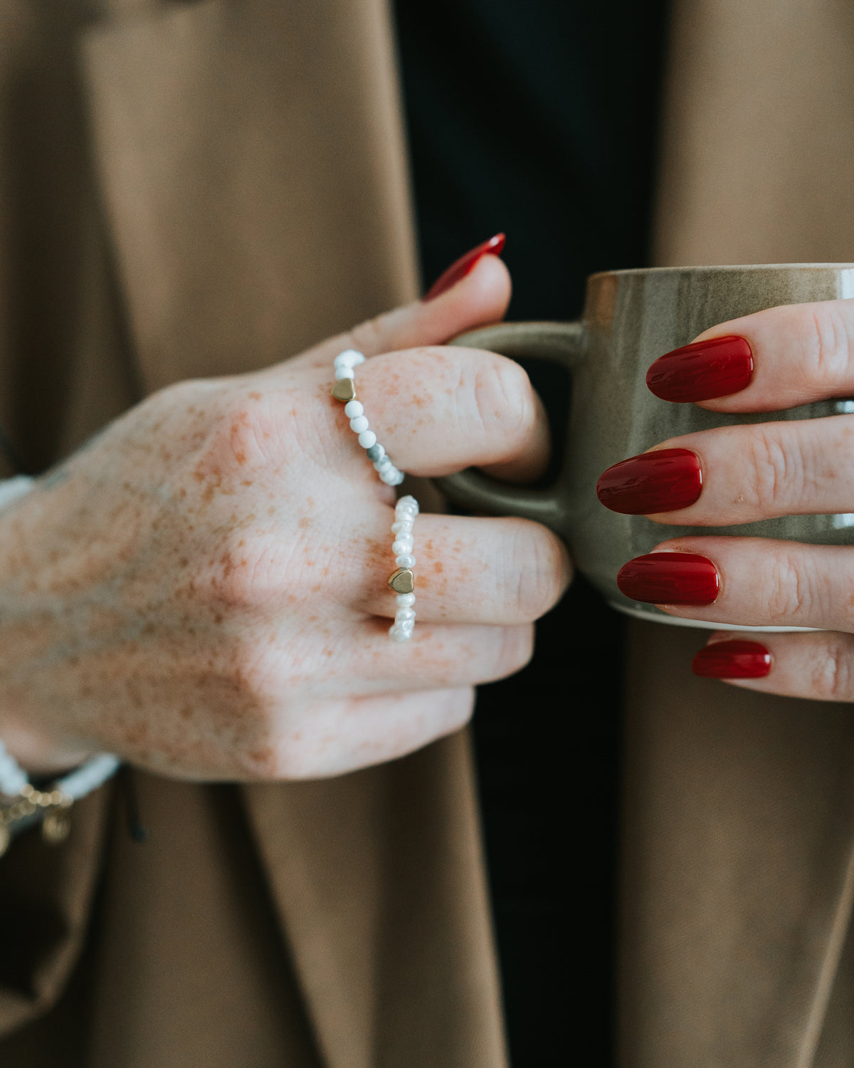 Hand mit Howlith-Ring und weiteren Ringen.