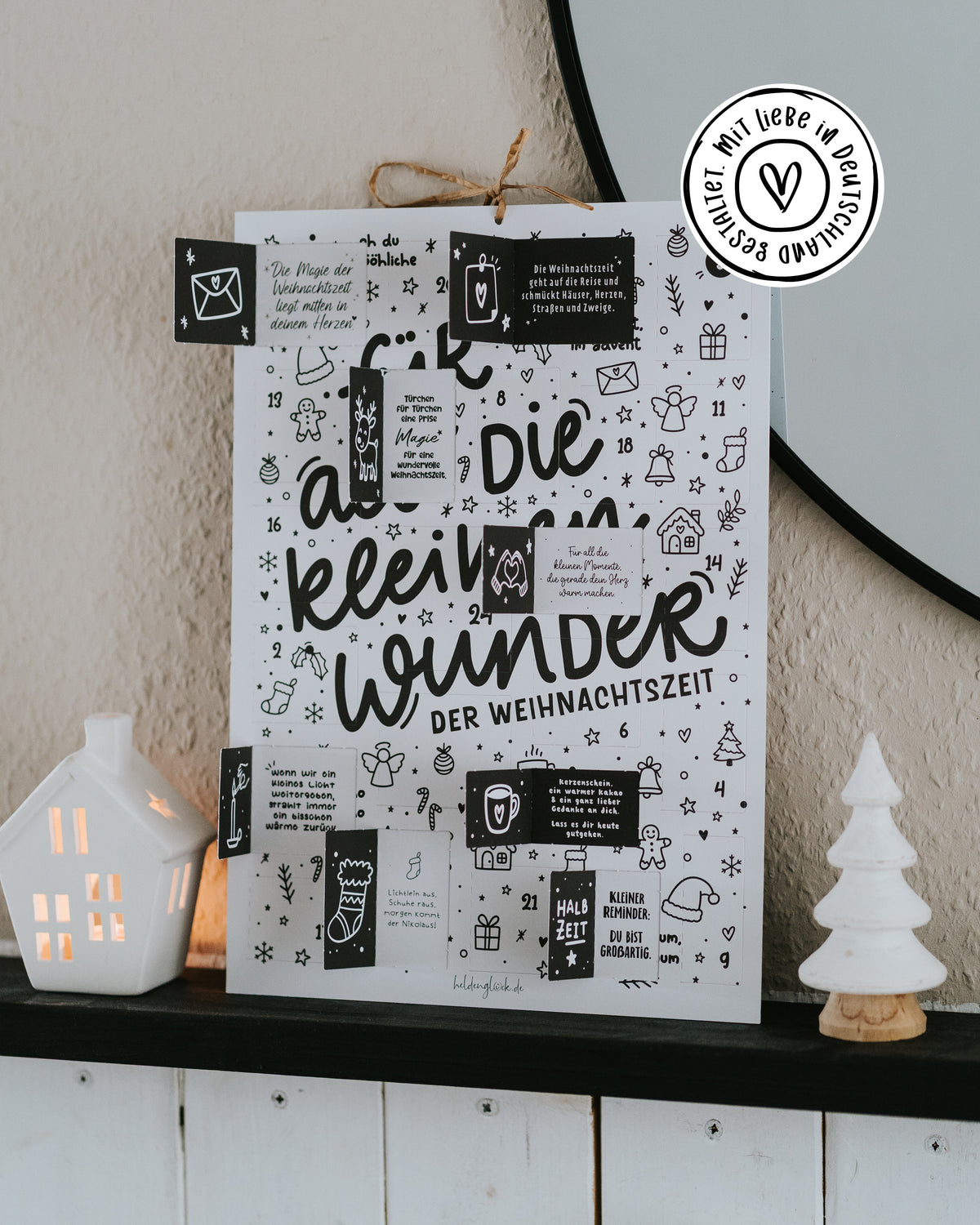 Adventskalender mit geöffneten Türchen auf dem Sideboard, Siegel „Mit Liebe in Deutschland gestaltet“.