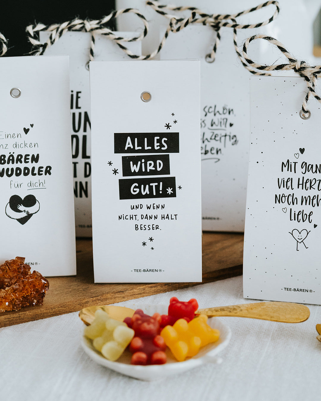 Mehrere Teebären-Motive nebeneinander, Alles wird gut mittig, Schale mit bunten Bärchen.