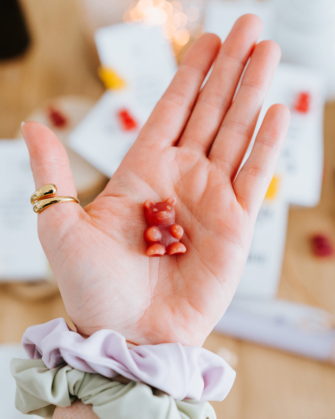 Hand hält ein rotes Teebärchen als Größenreferenz – als Tee aufgießen oder direkt naschen.