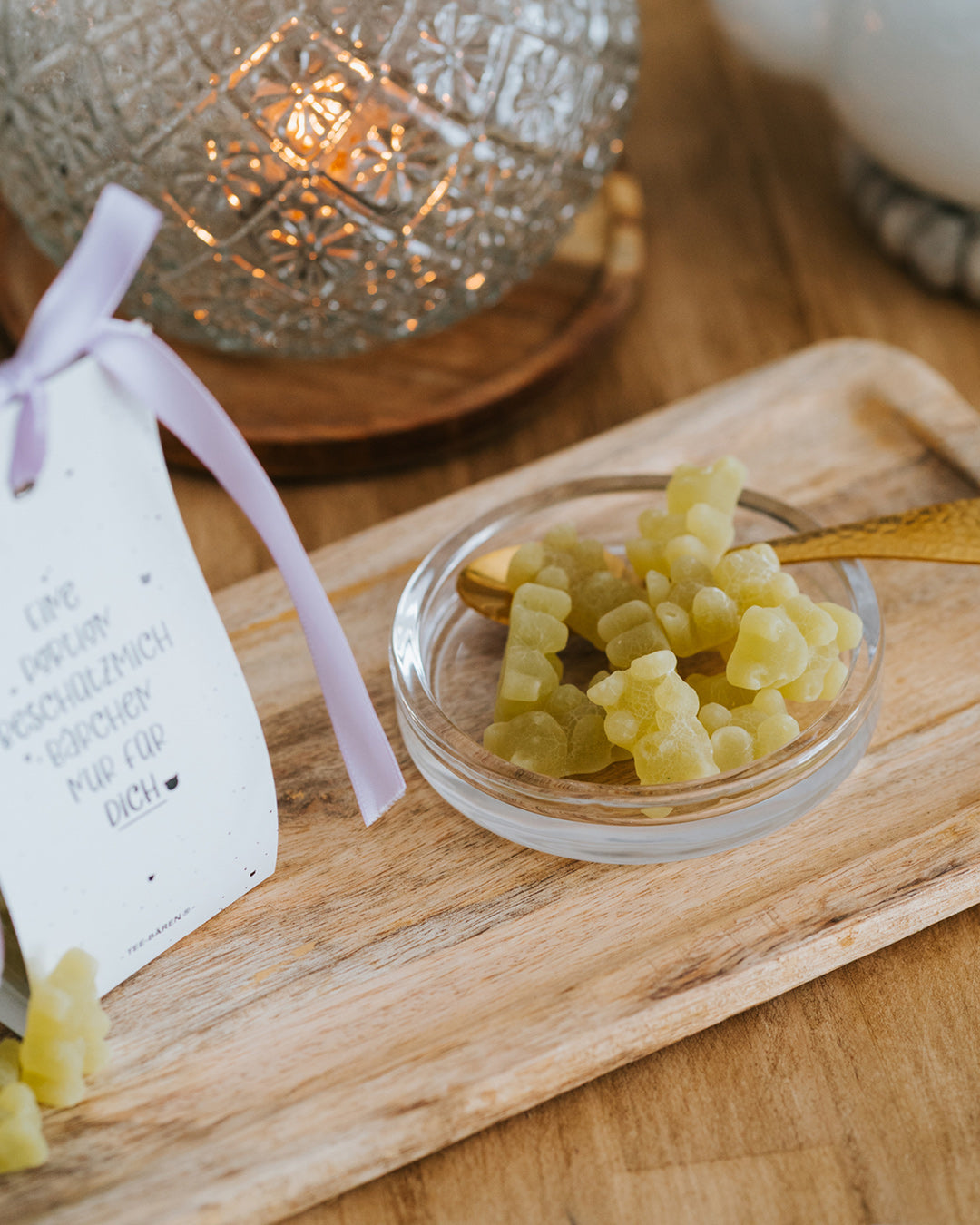 Limettengrüne Fruchtgummi-Bärchen in der Glasschale mit Goldlöffel – als Tee oder zum Naschen.