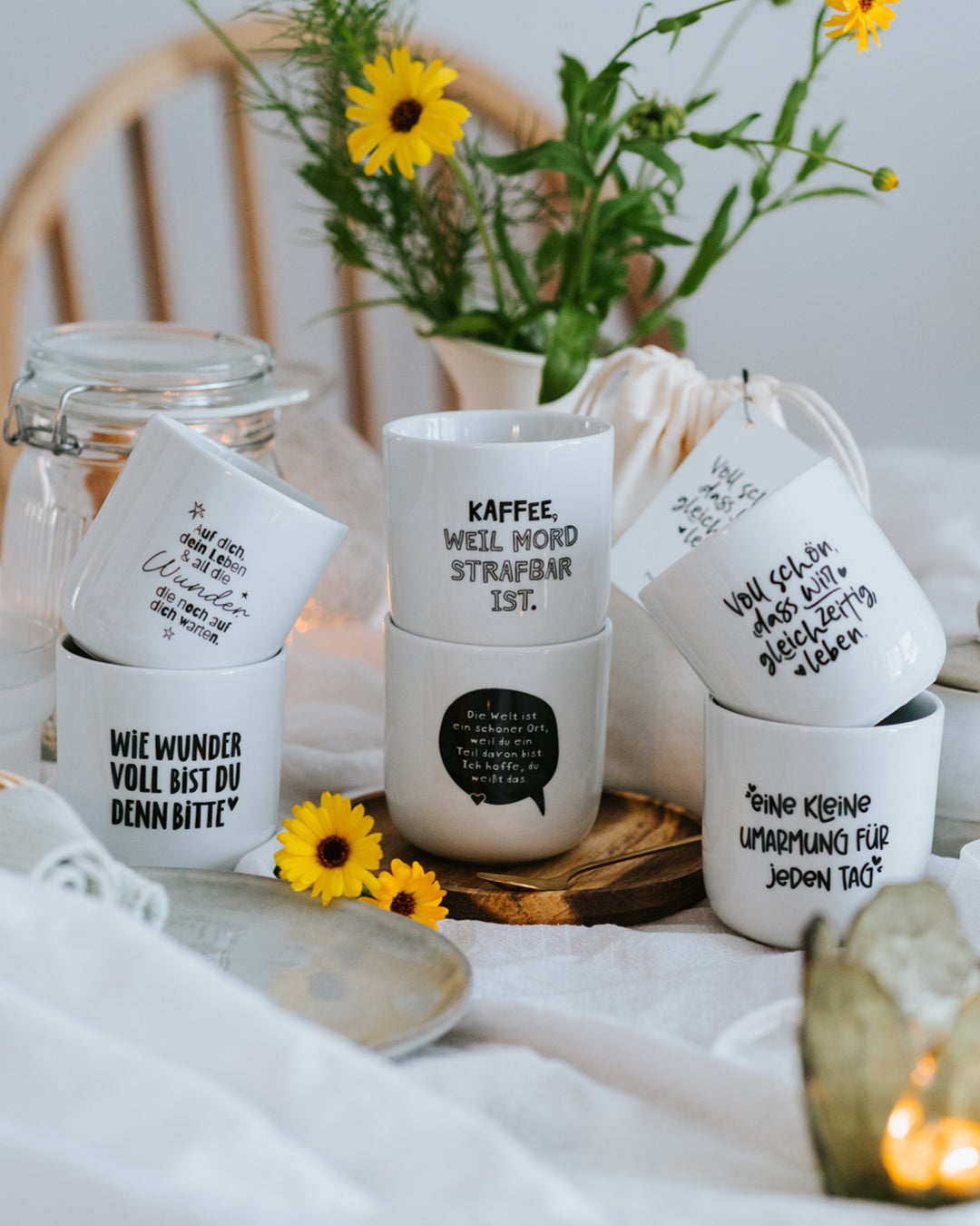 Sechs Heldenglück-Porzellanbecher mit Blumen und Geschenkbeuteln – alle Motive im Überblick.