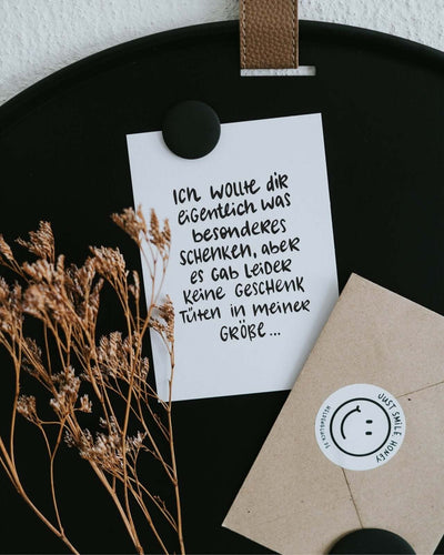 Postkarte mit Spruch und motiv Geschenktüte in schwarz weiss