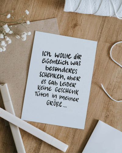 Postkarte mit Spruch und motiv Geschenktüte in schwarz weiss