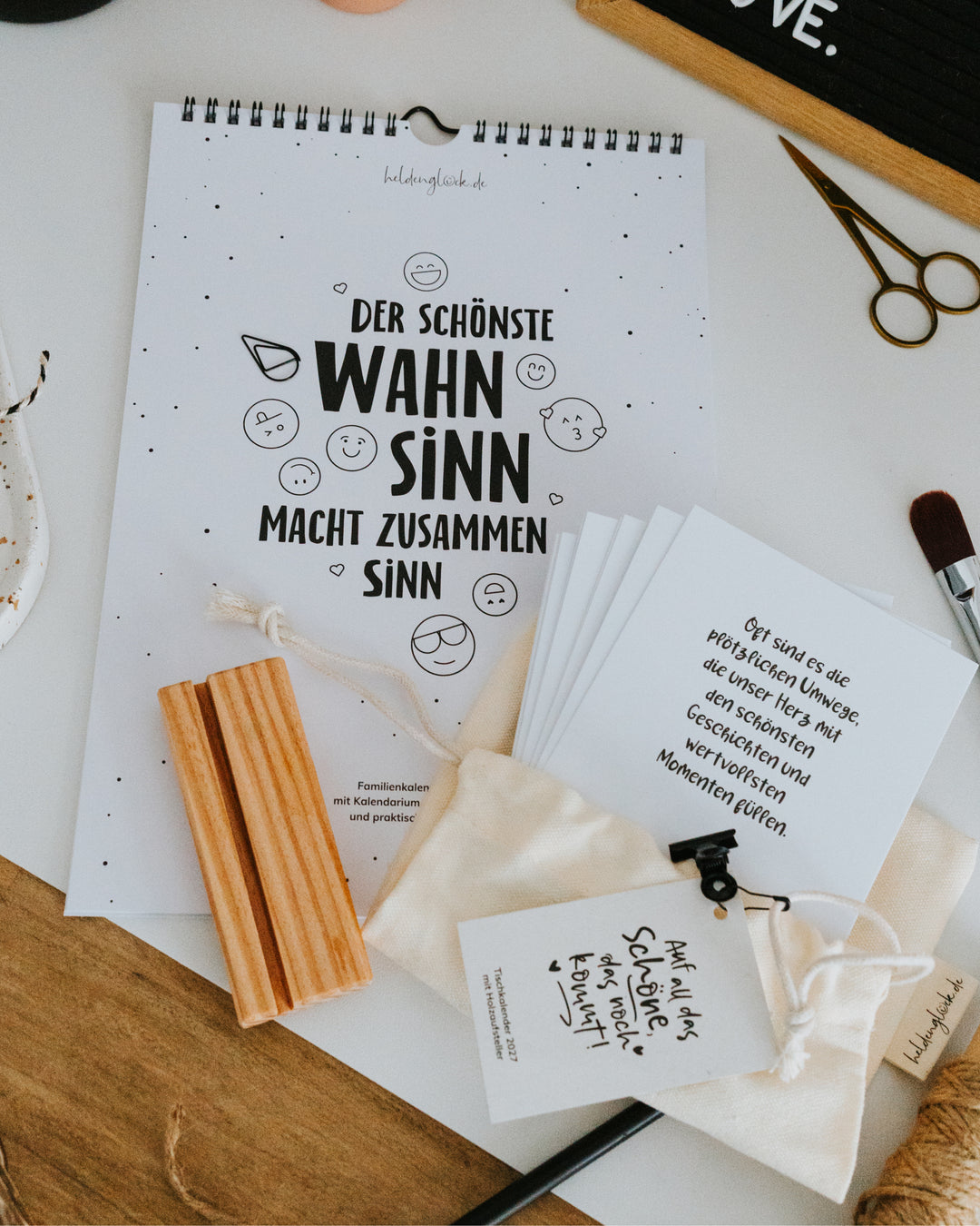 Kalender-Set von oben: Familienkalender, 12 Monatskarten DIN A6 auf 300 g Naturpapier, Holzständer, Klammer und Baumwollbeutel.