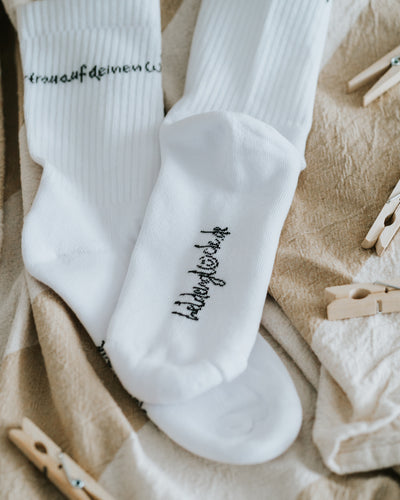 Socken auf weicher Decke – Baumwollmischung mit Polyamid und Elasthan.