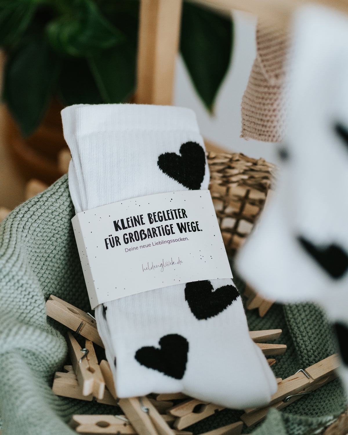 Herz-Socken mit Banderole im Korb – geschenkfertig verpackt.