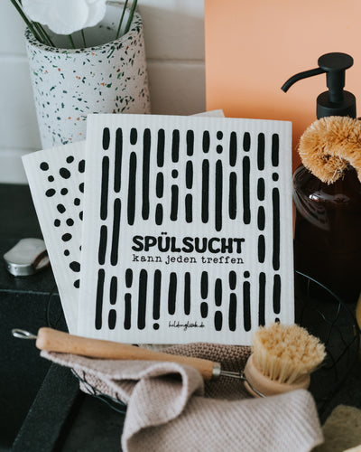 Schwammtuch „Spülsucht kann jeden treffen“ an der Spüle.