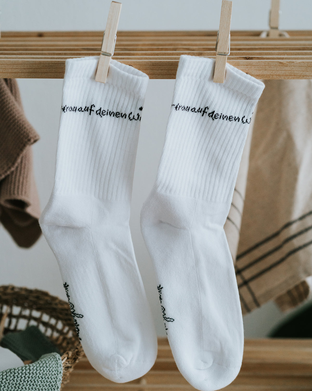 Weiße Socken an der Wäscheleine mit Schriftzug am Bund – stilvolles Schwarz-Weiß-Design.