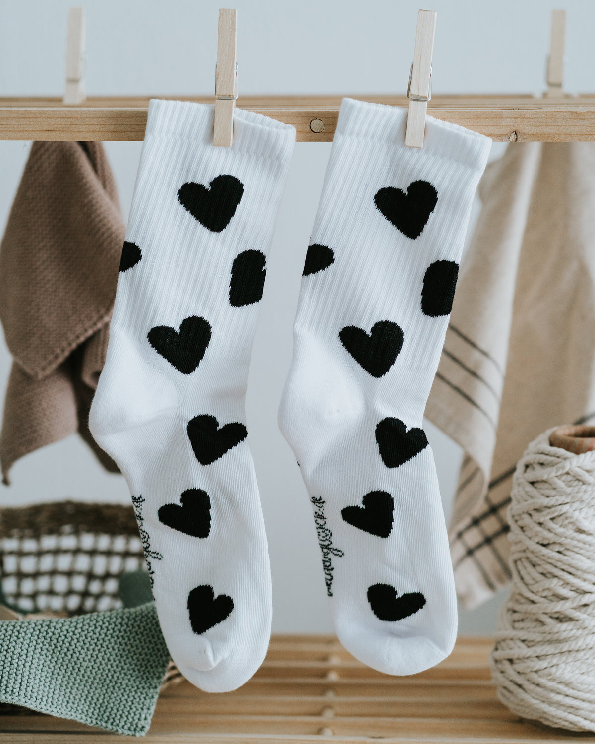 Weiße Socken mit schwarzen Herzen an der Wäscheleine – stilvolles Schwarz-Weiß-Design.