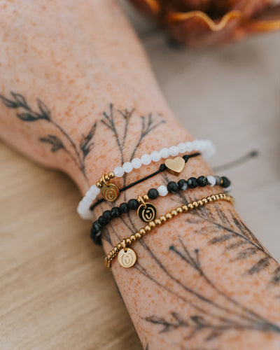 Baumwoll-Armband am Handgelenk, mit Naturstein-Armbändern kombiniert.