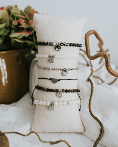 Mehrere Armbänder am Schmuckständer, Edelstahl in Silber vorn.