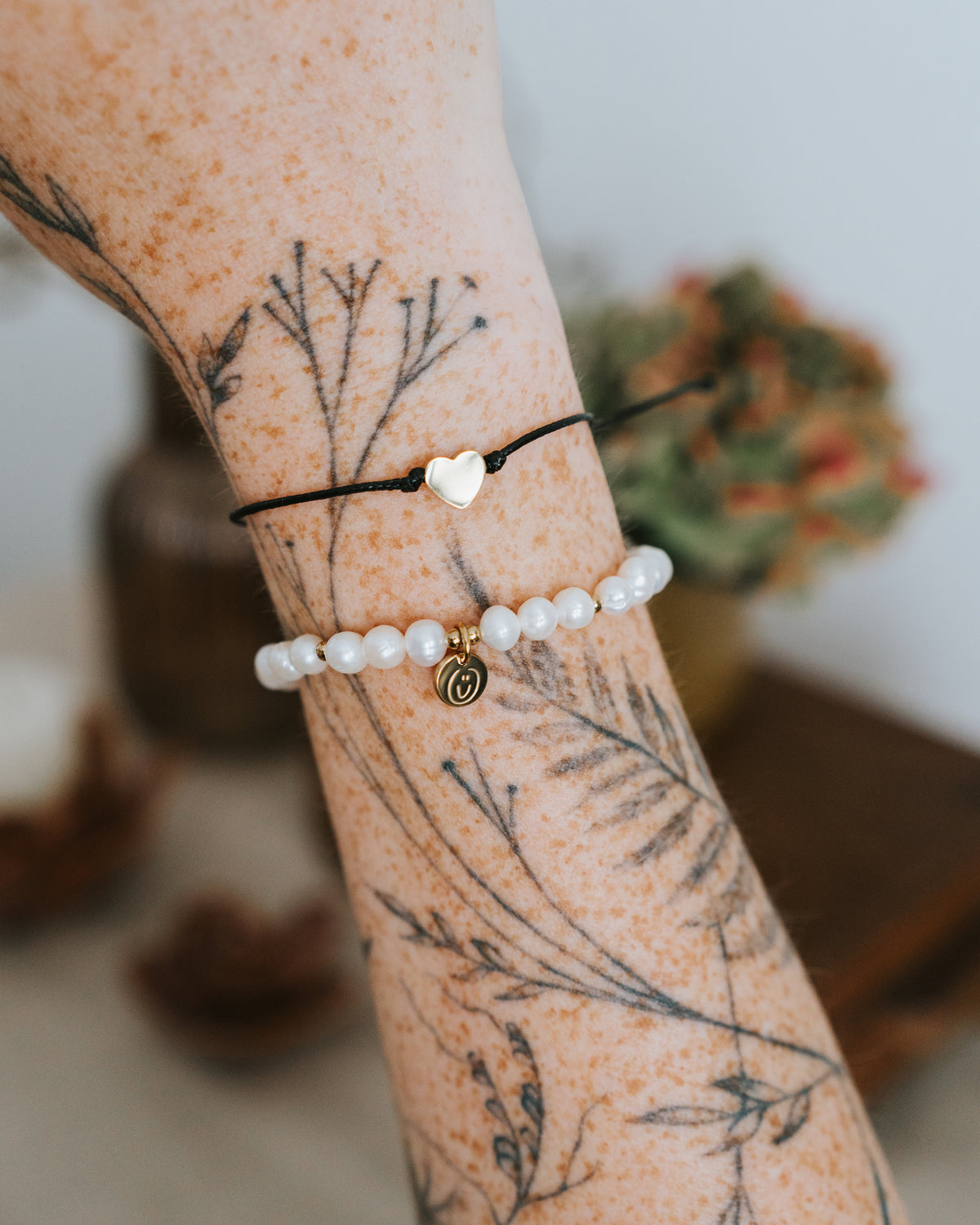 Süßwasserperlen-Armband in Gold am Handgelenk getragen.