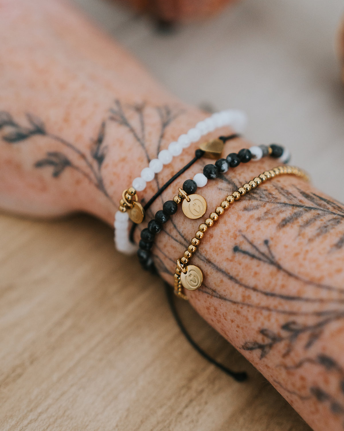 Zebra-Jaspis-Armband in Gold am Handgelenk getragen.