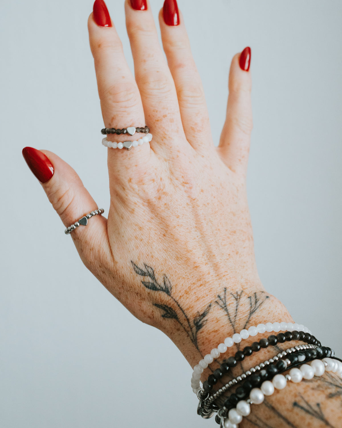 Zebra-Jaspis-Armband in Silber an der Hand, mit Perlen kombiniert.