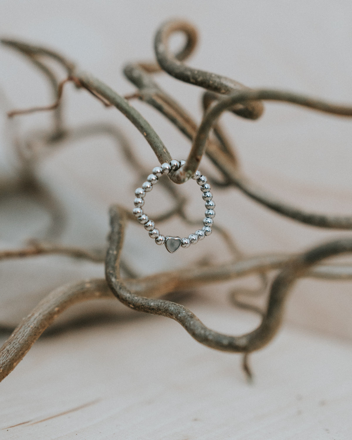 Edelstahl-Ring in Silber an Zweigen – silberne Kugeln mit silbernem Herz.