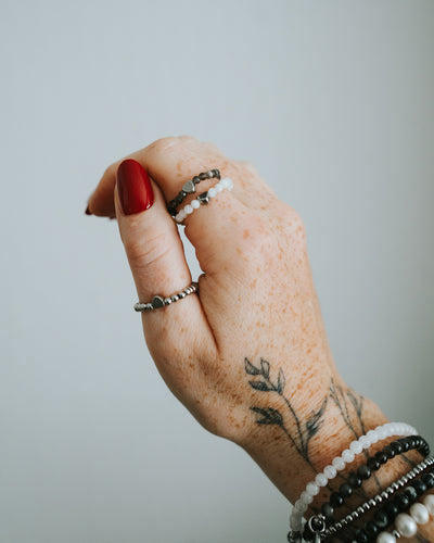 Edelstahl-Ring in Silber am Finger getragen, mit Armbändern kombiniert.
