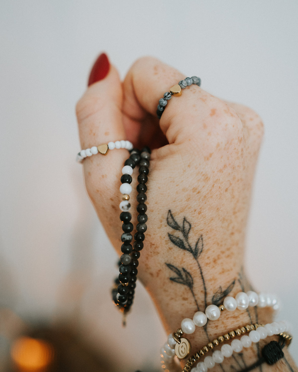 Howlith-Ring am Finger getragen, mit Armbändern kombiniert.