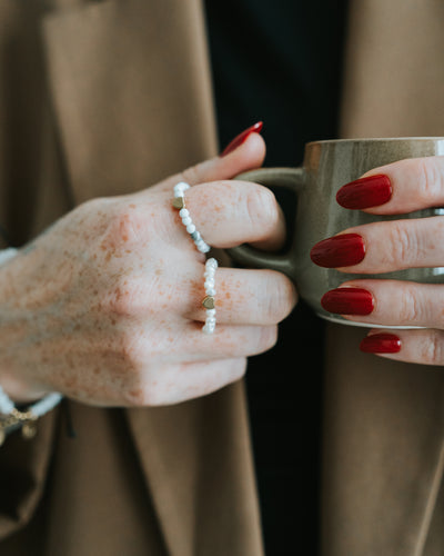 Hand mit Howlith-Ring und weiteren Ringen.