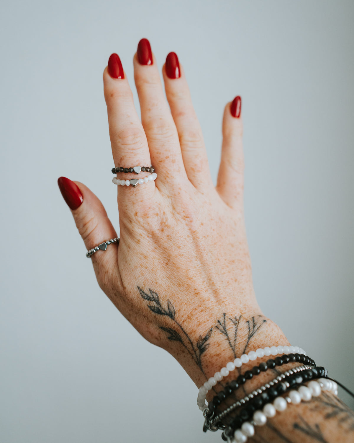 Hand mit Mondstein-Ring und weiteren Ringen.