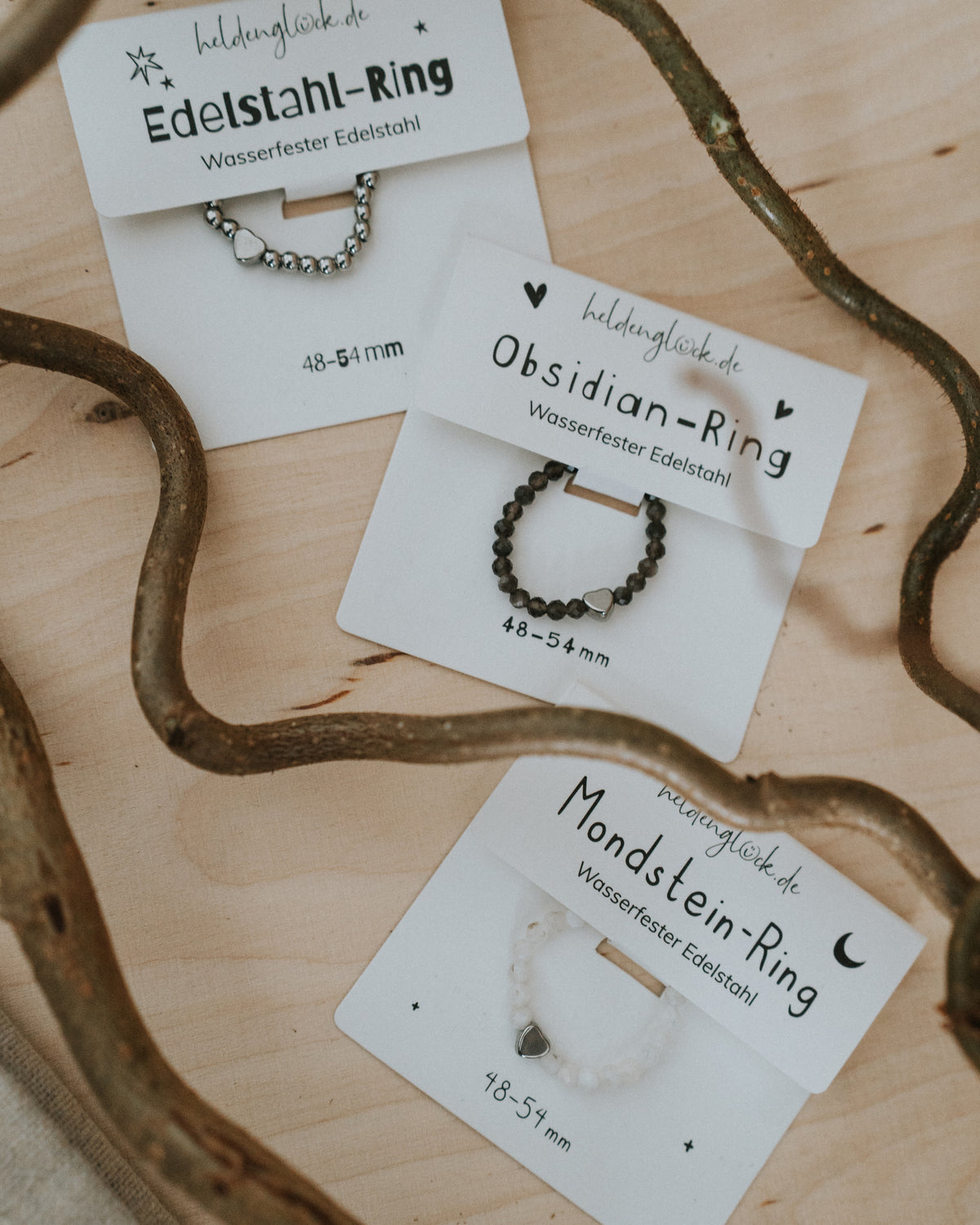 Ring-Karten nebeneinander – Obsidian, Edelstahl und Mondstein.