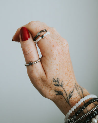 Obsidian-Ring am Finger getragen, mit Armbändern kombiniert.