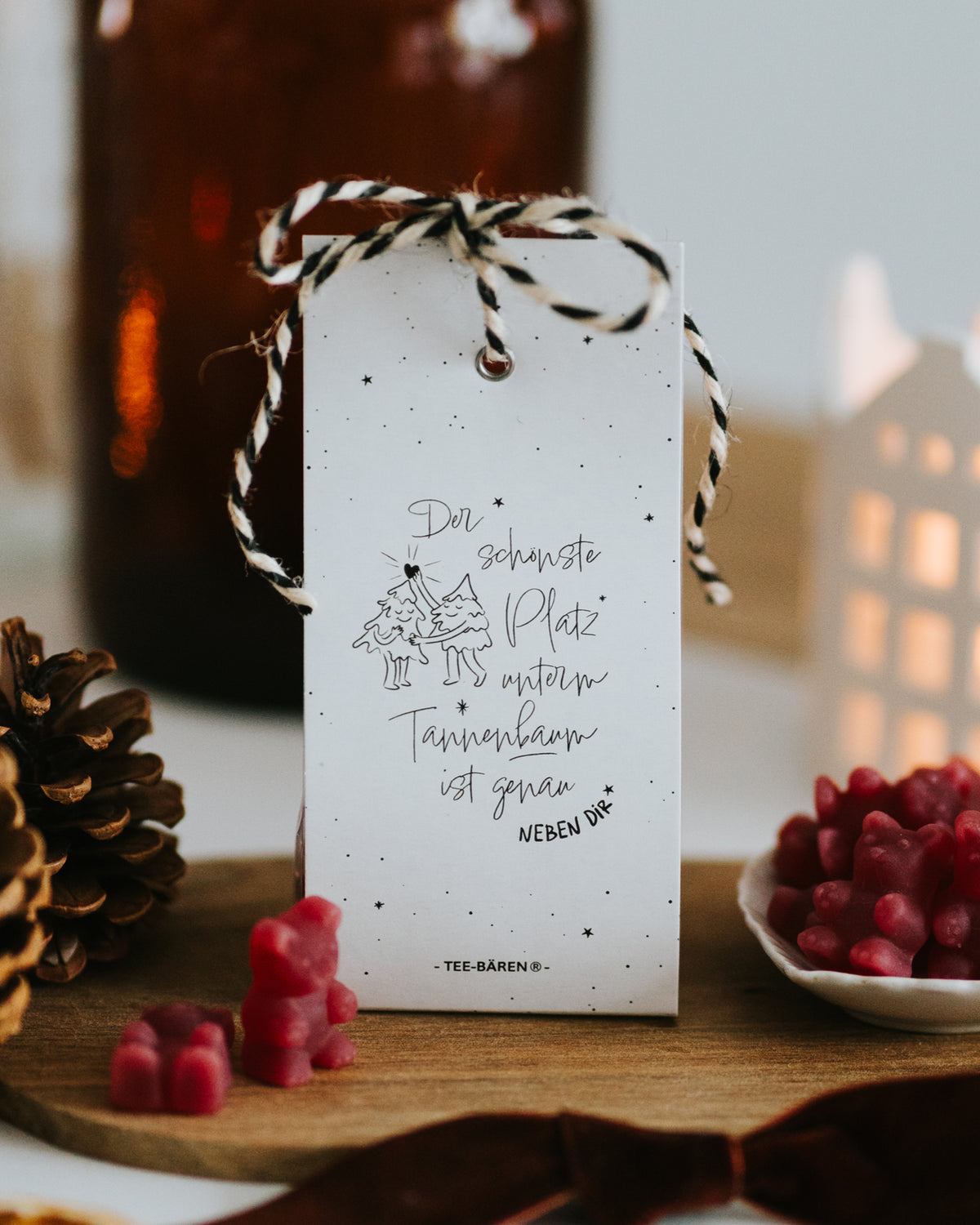Teebären „Der schönste Platz unterm Tannenbaum ist genau neben dir“ mit schwarz-weißer Kordel und Tannenbaum-Illustration.