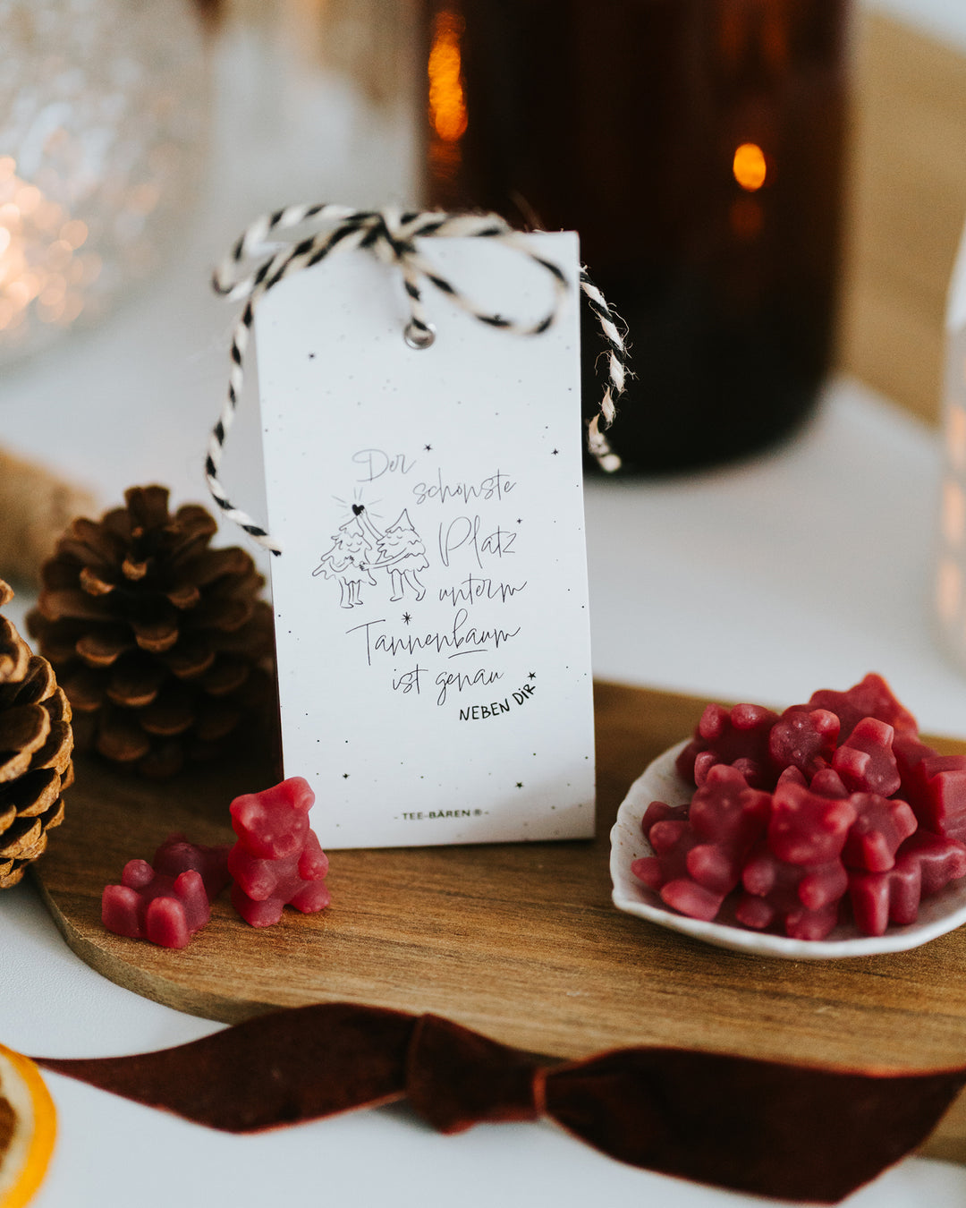 Teebären „Der schönste Platz unterm Tannenbaum“ auf Holzbrett mit Zapfen und Samtband – geschenkfertig verpackt, 60 g.