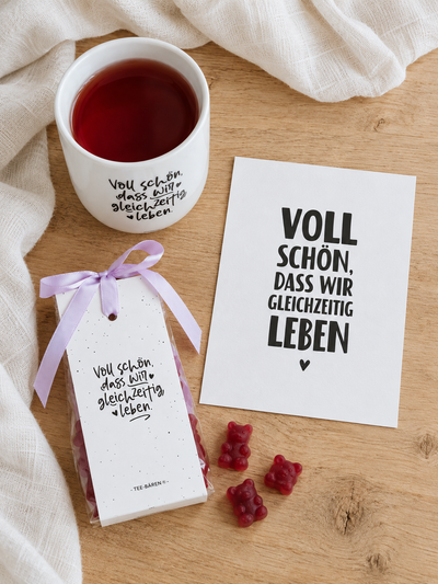 Voll-schön-Geschenkset in der Draufsicht: Becher, Teebären und Postkarte mit dem Spruch Gleichzeitig leben.