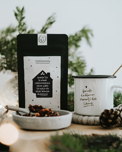 Lebkuchenhaus von Heldenglück, Früchtetee Weihnachtsmandel: Teepackung neben einer Tasse.