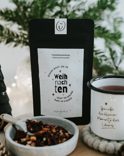 Ruhe schenken von Heldenglück, Früchtetee Weihnachtsmandel: Teepackung neben einer Tasse.