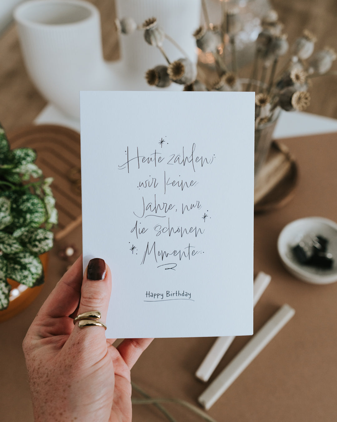 Hand hält Klappkarte zum Geburtstag mit feinem Handlettering und Happy-Birthday-Schriftzug