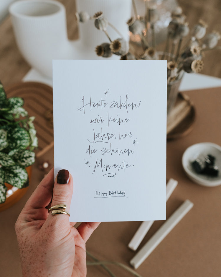 Hand hält Klappkarte zum Geburtstag mit feinem Handlettering und Happy-Birthday-Schriftzug