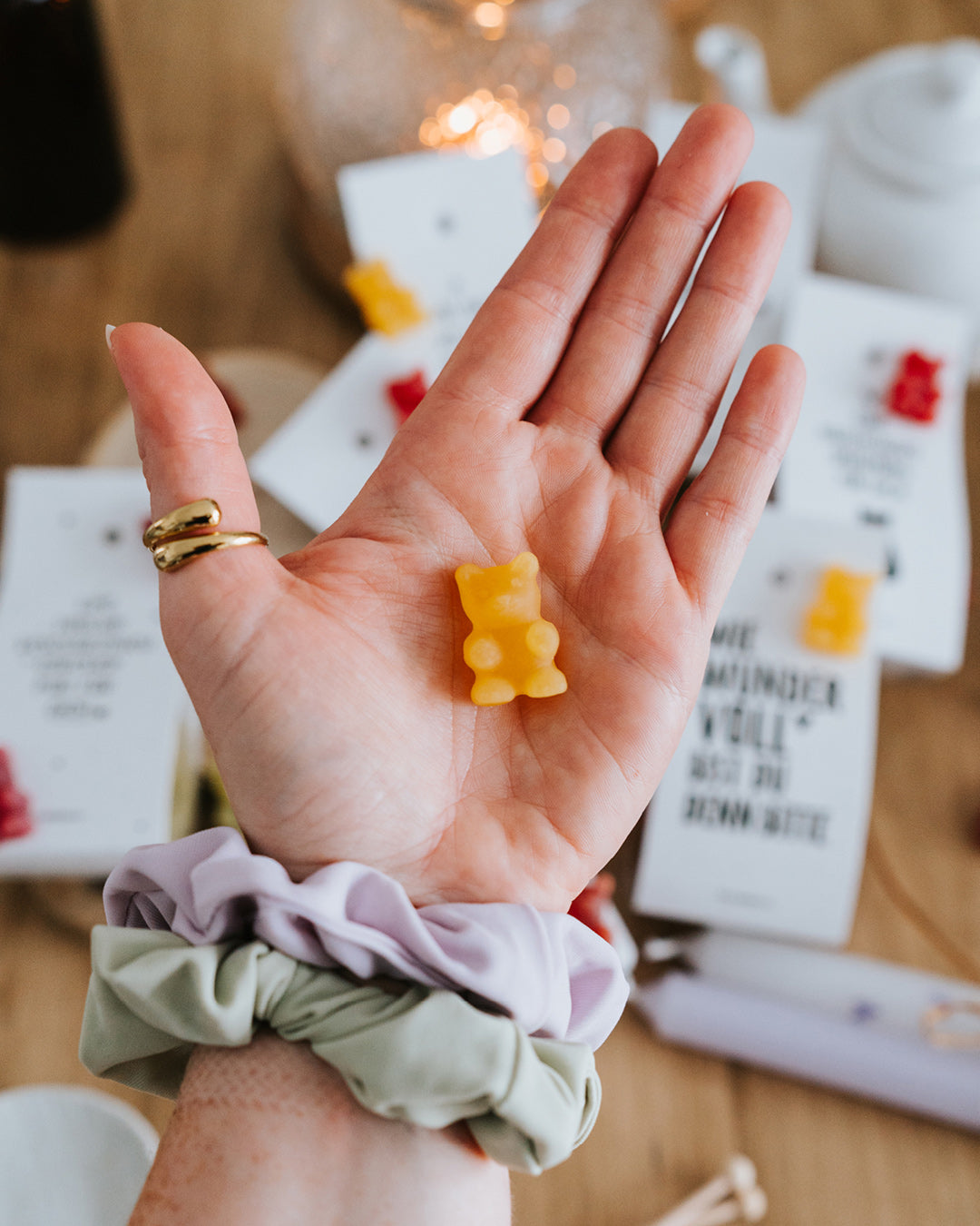 Hand hält ein gelbes Teebärchen – als Tee aufgießen oder direkt naschen.