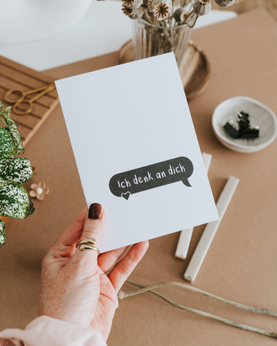 Hand hält Klappkarte „Ich denk an dich" – hochwertiges Papier, reduziertes Schwarz-Weiß-Design