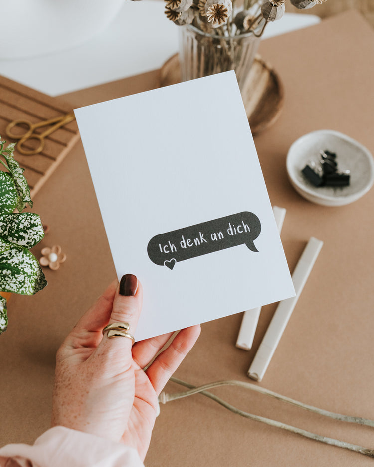 Hand hält Klappkarte „Ich denk an dich" – hochwertiges Papier, reduziertes Schwarz-Weiß-Design