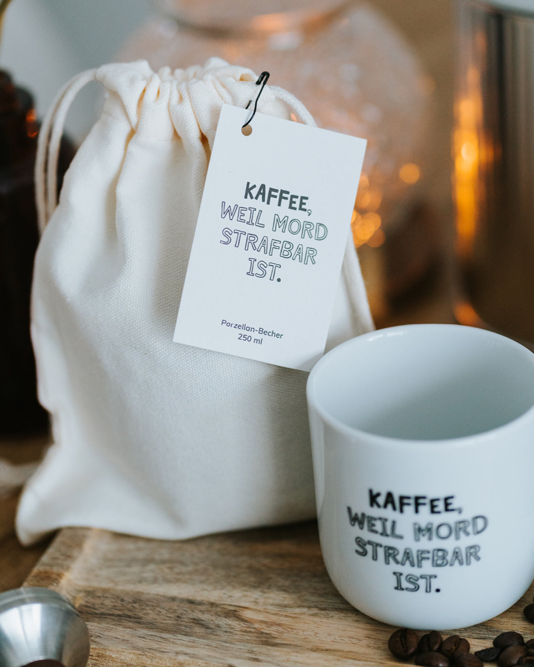 Baumwollbeutel mit Anhänger und Porzellanbecher „Kaffee, weil Mord strafbar ist.“ – 0,25 l, direkt verschenkbar.