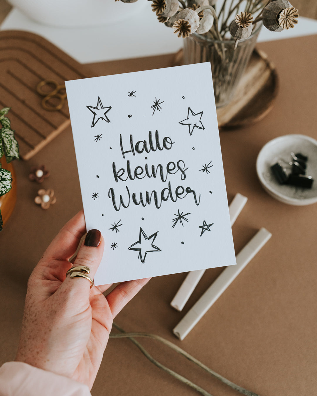 Hand hält Geburtskarte „Hallo kleines Wunder" auf hochwertigem Papier im Hochformat