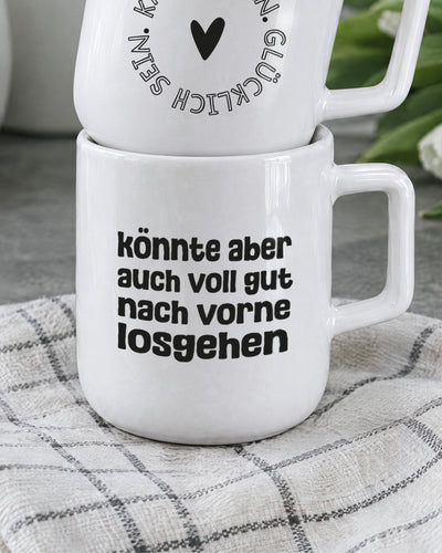 Porzellantasse mit Spruch „könnte aber auch voll gut nach vorne losgehen“ in kräftiger Typo.