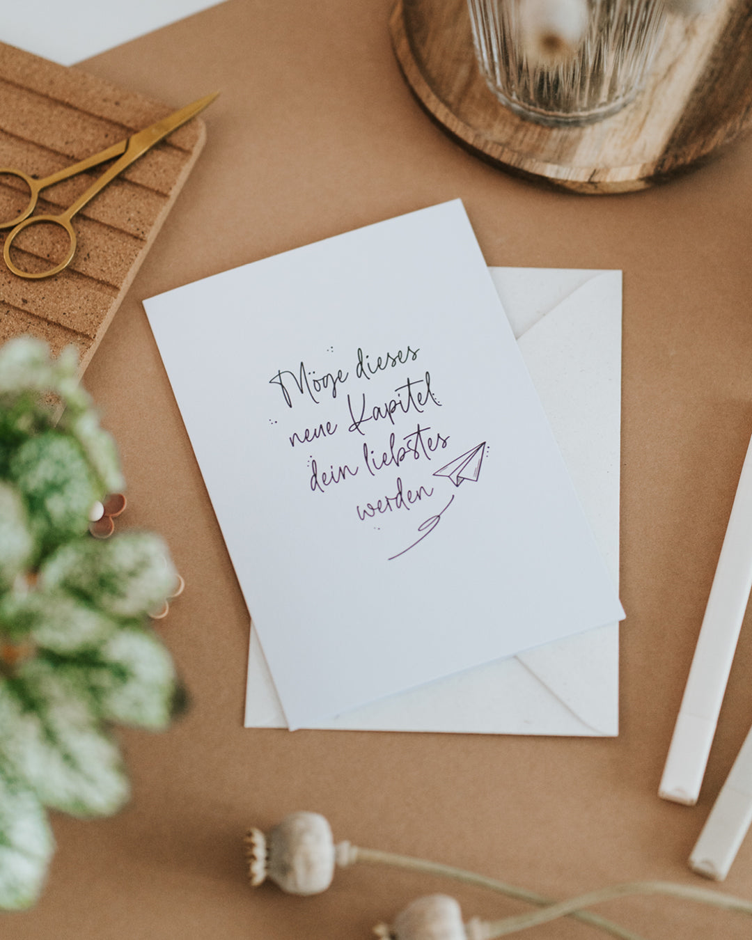Karte zum Neuanfang mit Papierflieger-Motiv, liegend auf passendem Umschlag