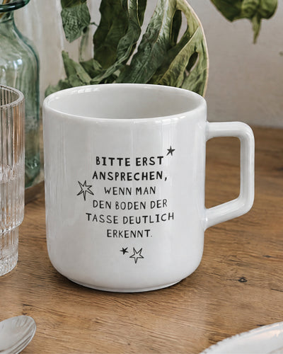 Porzellantasse mit Spruch „Bitte erst ansprechen, wenn man den Boden der Tasse deutlich erkennt.“
