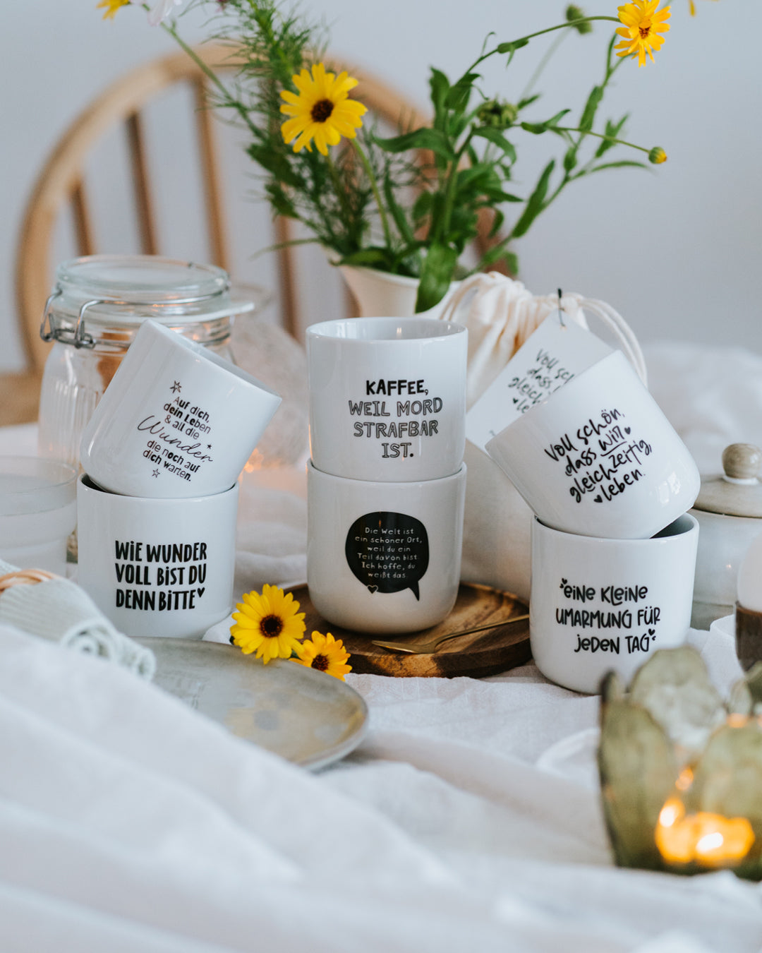 Sechs Heldenglück-Porzellanbecher mit Blumen und Geschenkbeuteln – liebevoll verpackt, direkt verschenkbar.