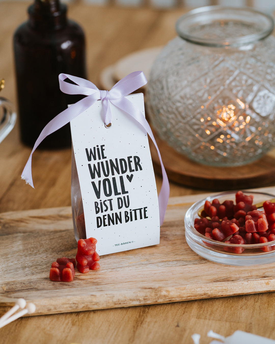Teebären Wie wundervoll mit fliederfarbener Schleife vor Windlicht – geschenkfertig verpackt.
