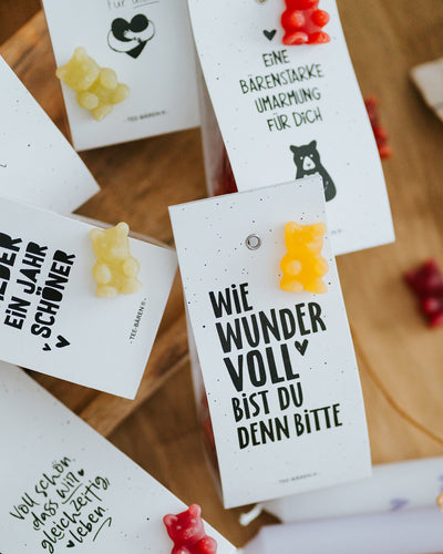 Draufsicht auf mehrere Teebären-Motive mit dunkelroten und gelben Fruchtgummi-Bärchen.