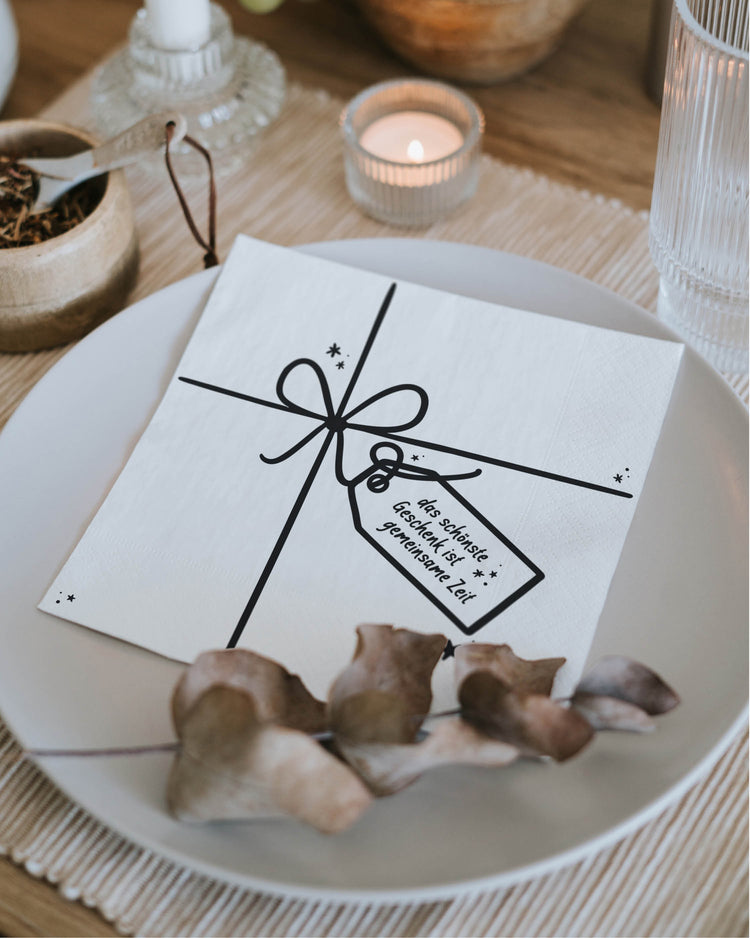 Festliche Serviette im Geschenk-Look mit liebevollem Spruch – perfekt für den Weihnachtstisch.