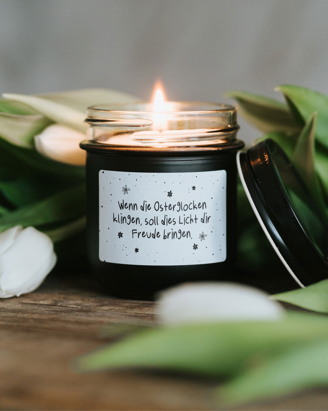 Minimalistische Osterkerze im Glas mit typografischem Spruch und ruhigem Design