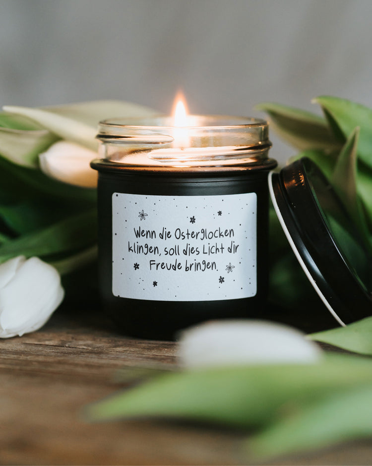 Minimalistische Osterkerze im Glas mit typografischem Spruch und ruhigem Design
